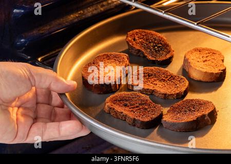 Fette di pane tostato bruciate dentro un forno, pane troppo cotto e carbonizzato Foto Stock
