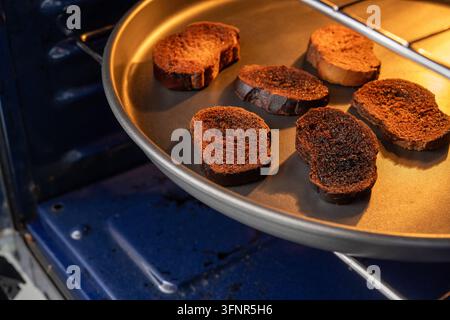 Fette di pane tostato bruciate dentro un forno, pane troppo cotto e carbonizzato Foto Stock