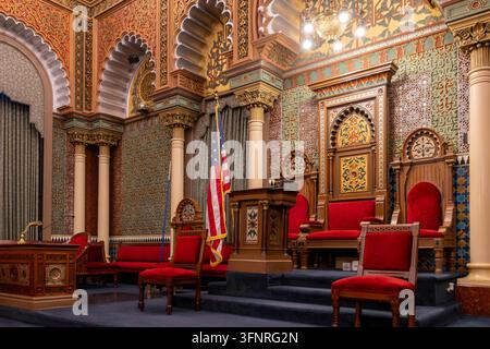 Filadelfia, Pennsylvania - 29 agosto 2026: Prospettiva a bassa angolazione di troni di legno rialzati, poltrone di velluto rosso, leggì e bandiera americana su da Foto Stock