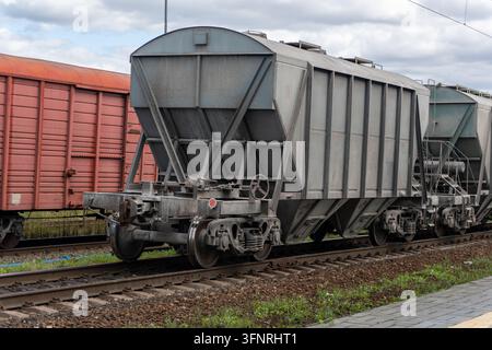 Carro merci industriale con benna parcheggiato sul binario ferroviario Foto Stock