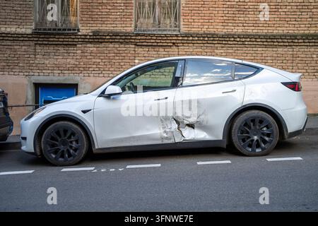 Povertà e lesinare sulle riparazioni dell'auto dopo un incidente, veicolo con portiera laterale danneggiata parcheggiato in strada Foto Stock