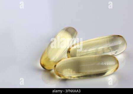 Capsule di olio di pesce Golden Omega 3 impilate a distanza ravvicinata isolate su superficie bianca Foto Stock