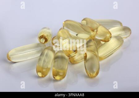Capsule di olio di pesce Golden Omega 3 impilate a distanza ravvicinata isolate su superficie bianca Foto Stock