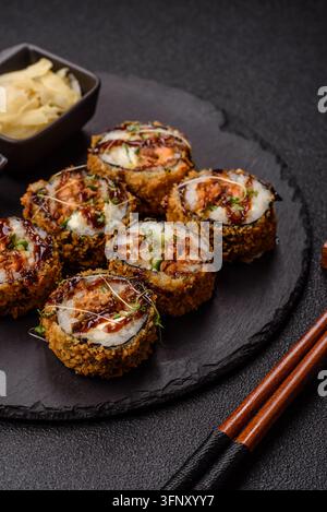 Rotoli di sushi tempura caldi con tonno, riso, salsa di soia, wasabi e zenzero. Rotolo di tempura al tonno caldo come sfondo alimentare per il tuo design. Foto Stock