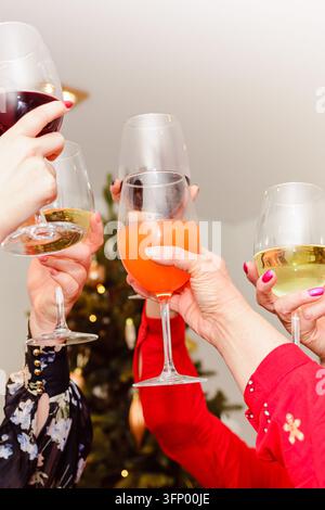 Gruppo di persone che applaudono con bicchieri di vino durante le festività invernali. Foto Stock