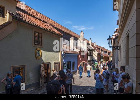 Praga, Repubblica Ceca - 30 maggio 2026: Gruppo di turisti sulla Via d'Oro (ceco: Zlata Ulicka) nel quartiere del Castello di Praga, piccole case su una strada acciottolata Foto Stock