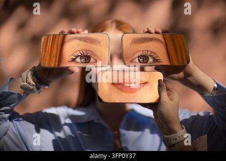 Donna sorridente posa dietro tre cornici rettangolari che mostrano occhi e bocca ingranditi, mentre diverse mani tengono gli oggetti di scena davanti a uno sfondo sfocato Foto Stock
