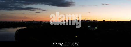 Il réservoir di Brent che riflette lo spettacolare skyline urbano di Londra al crepuscolo. Una vasta vista panoramica di Wembley al tramonto, con l'arco illuminato di Wembley S Foto Stock