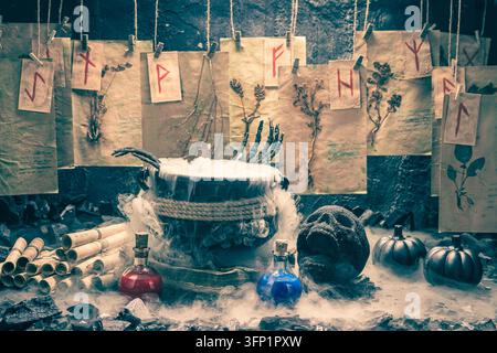 Un calderone ribolle con un fumo bianco e denso. Fiale di pozioni riposano su una superficie scura. Sfondo Halloween per un progetto di evento. Foto Stock