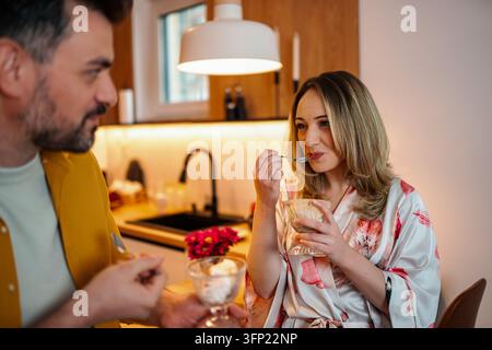Coppia che gusta insieme il dessert della colazione in cucina Foto Stock