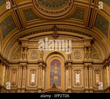 Filadelfia, Stati Uniti - 29 agosto 2026: Dettaglio architettonico ascendente di un frontone neoclassico ornato, capitelli di cherubini dorati e archi religiosi Foto Stock
