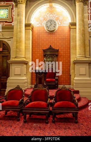 Filadelfia, Stati Uniti - 29 agosto 2026: Vista verticale simmetrica di un palco rialzato per maestro, sedie intagliate, orologio con numeri romani e colonna in marmo Foto Stock