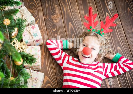 Bambino felice che indossa il renna Rudolph. Bambino divertente alla vigilia di Natale. Concetto di vacanza natalizia Foto Stock
