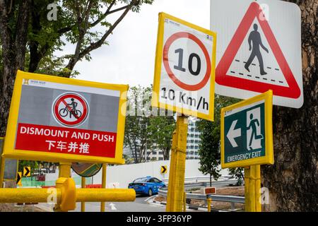 Segni di avvertimento per pedoni e ciclisti a Clarke Quay, Singapore. Foto Stock