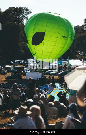 Bristol Balloon Fiesta, 7 agosto 2026, Regno Unito – Mongolfiera aliena verde gonfiata davanti agli alberi e ai visitatori del festival Foto Stock