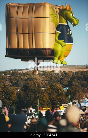 Festa dei palloncini di Bristol, 7 agosto 2026, Regno Unito – Un drago gigante e un pallone ad aria calda a forma quadrata sorvolano gli alberi del festival Foto Stock