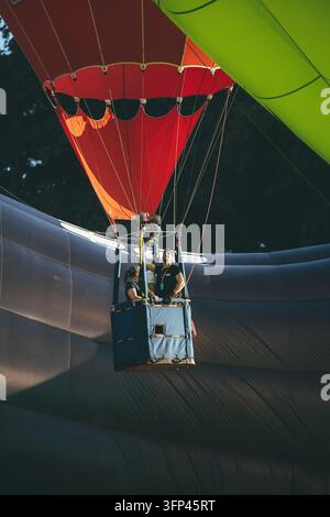 Festa dei palloncini di Bristol, 7 agosto 2026, Regno Unito – Cestini di mongolfiere con piloti che si preparano al volo all’interno delle pieghe dell’involucro Foto Stock