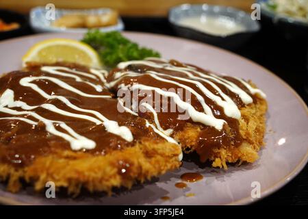 Costolette di maiale croccante o tonkatsu servita con salsa marrone e maionese sopra Foto Stock