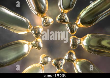 Fotografia macro orizzontale con un disposizione circolare e radiale di capsule di siero cosmetico dorate o ampolle di olio su uno sfondo scuro e suggestivo Foto Stock