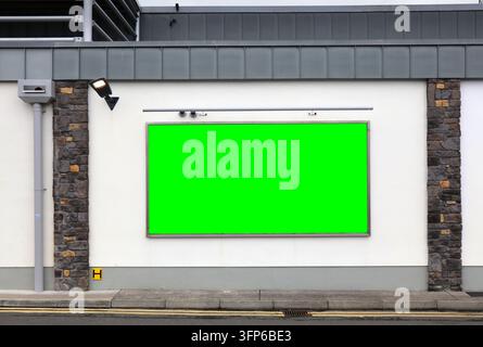 Insegna pubblicitaria vuota. Pubblicità cromatica verde vuota con spazio per il testo su un edificio di supermercato generico in Europa. Foto Stock