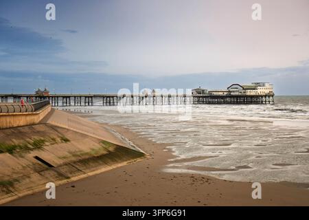 Vista panoramica del North Pier di Blackpool al crepuscolo con cielo al tramonto e onde che si infrangono sulla spiaggia Foto Stock