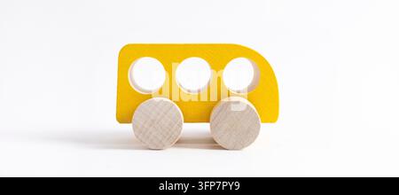 Macchina giocattolo in legno in stile cartone animato su sfondo bianco. Sfondo colorato e di trasporto, giocattolo ecologico per bambini Montessori, vista laterale isolata Foto Stock