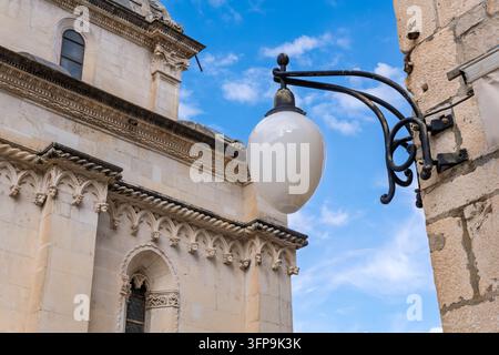 Lampione classico davanti alla facciata in pietra ornata della storica Cattedrale di San Giacomo a Sibenik. Dettaglio architettonico della Cattedrale di San Giacomo Foto Stock