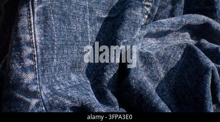 Tessuto denim blu piegato con cuciture visibili Foto Stock