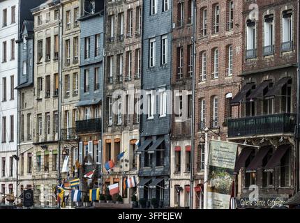 Le caratteristiche facciate strette e alte degli edifici lungo il porto storico di Honfleur in Normandia. Foto Stock