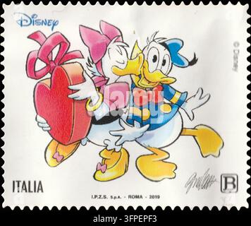 Francobollo italiano della serie Disney 2019 con Paperina che abbraccia Paperone mentre tiene una scatola regalo a forma di cuore, tariffa B. Foto Stock