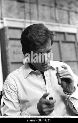 Sir Roger Moore, 1927-2017 durante le riprese del film Il uomo con la pistola d'oro ai Pinewood Studios. Roger Moore è noto per il suo ruolo di agente James Bond, interpretato nel personaggio in sette film. 1974. Foto Stock