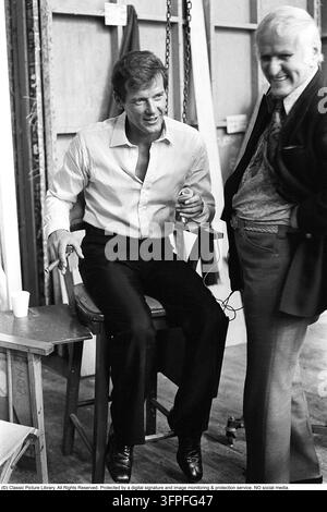 Sir Roger Moore, 1927-2017 durante le riprese del film Il uomo con la pistola d'oro ai Pinewood Studios. Roger Moore è noto per il suo ruolo di agente James Bond, interpretato nel personaggio in sette film. 1974. Foto Stock