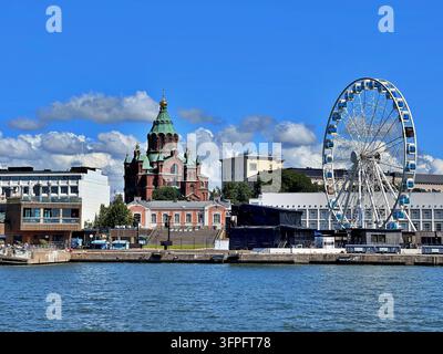 SkyWheel Helsinki e la cattedrale Uspenski lungo il lungomare di Katajanokka, Helsinki, Finlandia, sotto un cielo estivo blu brillante. Foto Stock
