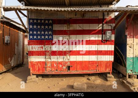 Capannone di legno consumato dipinto con un disegno della bandiera americana, Regione Centrale, Elmina, Ghana Foto Stock