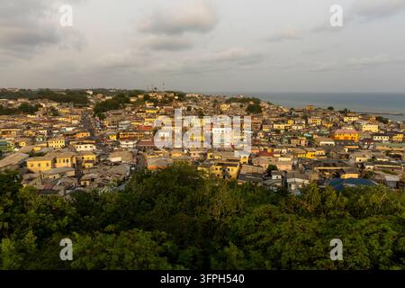 Vista panoramica sui tetti della città di Cape Coast con l'oceano sullo sfondo, Regione Centrale, Cape Coast, Ghana Foto Stock