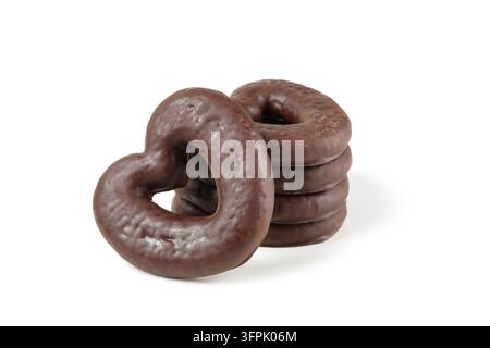 Biscotti di pan di zenzero al cioccolato. Pile di biscotti di pan di zenzero a forma di cuore glassati al cioccolato isolati su sfondo bianco. Pan di zenzero al cioccolato Foto Stock