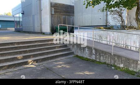 Scale in cemento e rampa accessibile con corrimano in metallo all'esterno di un edificio pubblico moderno Foto Stock