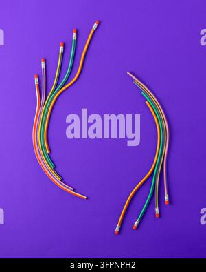 Ghirlanda creativa fatta di matite arcobaleno con gomme su uno sfondo viola vivace, con spazio per il testo. Concetto che rappresenta la scuola, cr Foto Stock