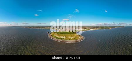 Vista aerea di Scarborough Castle sulla penisola che si affaccia sul Mare del Nord con la città sullo sfondo sotto un cielo blu sereno, Scarborough, Engla Foto Stock