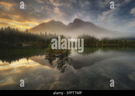 Vista del lago Hintersee al tramonto con nebbia che scorre sulla foresta e sulle montagne circostanti a Ramsau bei Berchtesgaden, Bavaria, Germania. Foto Stock