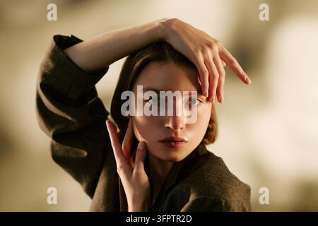 Ritratto di una donna che posa con le mani che toccano il viso in studio Foto Stock