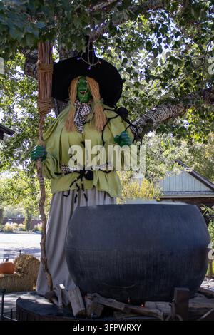 Decorazione di una strega accanto a un calderone sovradimensionato Foto Stock