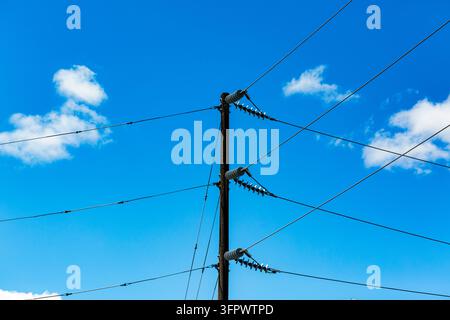 Palo telefonico e cavi, linee di comunicazione contro un cielo blu. Foto Stock