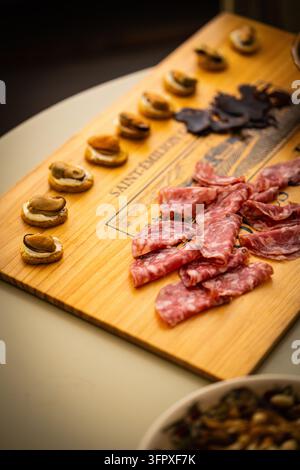 Salame affettato, carni stagionate, olive e canapè su un tavolo con coperchio di cassa del vino come antipasto in un lodge di caccia a Glen Clova, Scozia Foto Stock