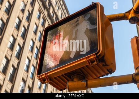 Primo piano di una mano rossa illuminata e di una figura pedonale spenta su un segnale di attraversamento pedonale a Lower Manhattan, New York City, sullo sfondo di Foto Stock