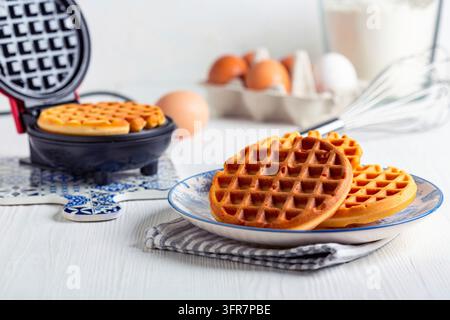 Mini gaufre belgiche fatte in casa in un ferro per waffle, messa a fuoco selettiva Foto Stock