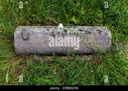 Prima di una lapide ebraica antica con un'iscrizione ebraica che giace nell'erba, provincia di Vayots Dzor, Eghegis, Armenia Foto Stock