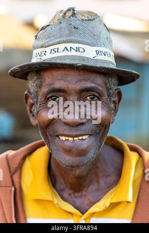 Ritratto di un uomo anziano sorridente con un cappello di paglia intrecciato e una camicia gialla, Menabe, Tsiribihina, Madagascar Foto Stock