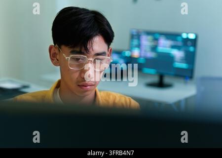 Giovane programmatore concentrato sullo sviluppo di software, sulla codifica, sull'intelligenza artificiale e sul lavoro con la tecnologia digitale. Foto Stock