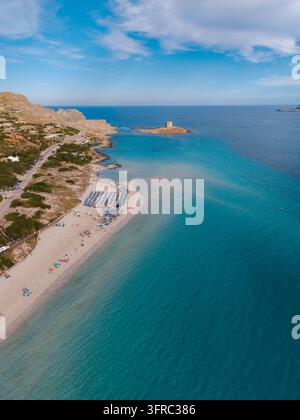 La spiaggia di La Pelosa in Sardegna, Italia, vanta acque cristalline e sabbie morbide. I turisti godono di una perfetta giornata estiva sotto il sole, creando un'atmosfera idilliaca Foto Stock